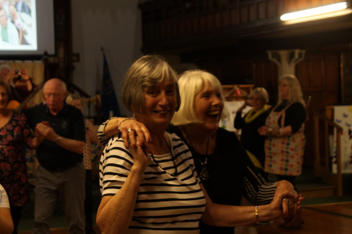 Image of two women laughing and dancing