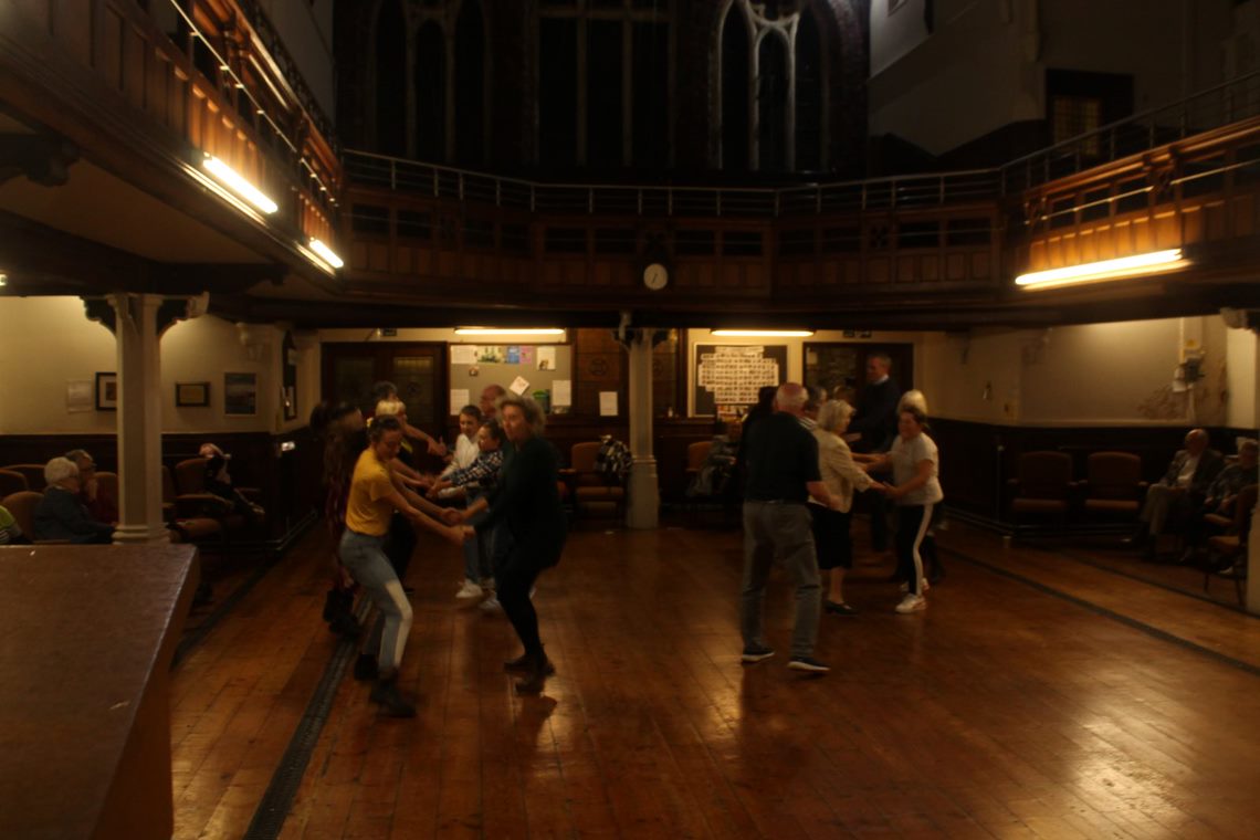 Image of people dancing a twmpath in the church